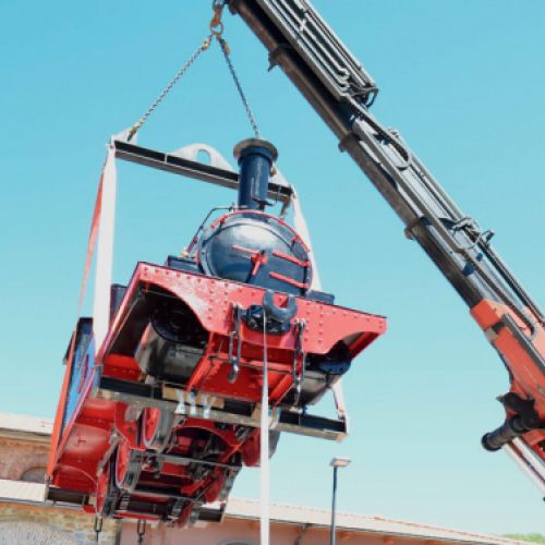 Colocación con grúa de la locomotora restaurada en la estación de tren de Cistierna