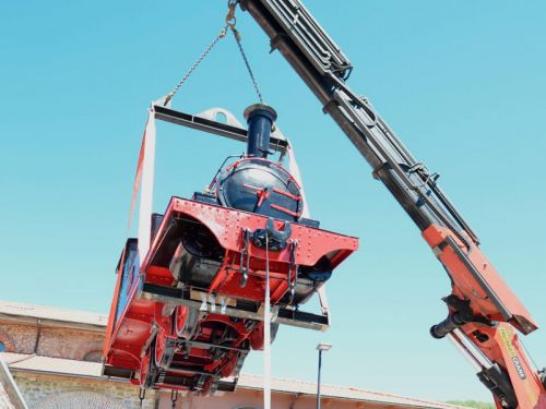 Colocación con grúa de la locomotora restaurada en la estación de tren de Cistierna